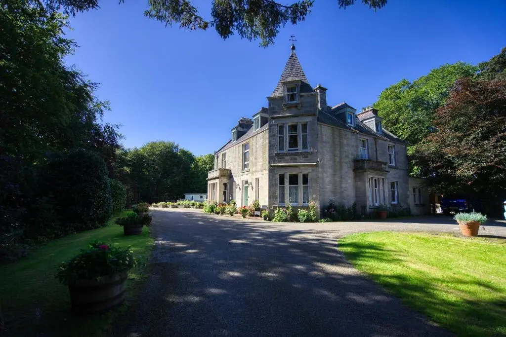 an old house with a tower on top of it at Woodlands Bed and Breakfast in Dornoch