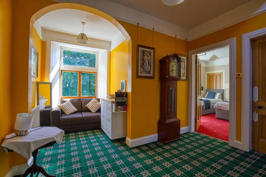a living room with yellow walls and a couch at Woodlands Bed and Breakfast in Dornoch