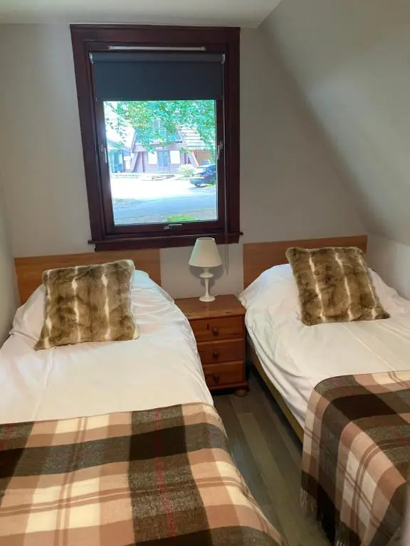 a bedroom with two beds and a window at Hayfield lodge in Spean Bridge