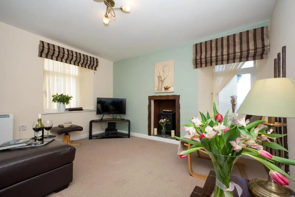 a living room with a couch and a tv at Finest Retreats - Ellie-Jo Cottage in Gardenstown