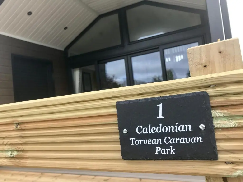 a sign on a wooden fence in front of a building at 2 Bed Self-Catering Lodge Inverness - Sleeps 4 in Inverness