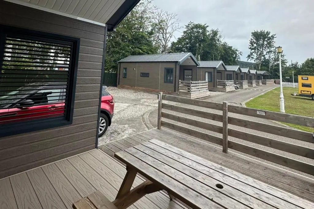 a wooden bench sitting on the side of a building at 2 Bed Self-Catering Lodge Inverness - Sleeps 4 in Inverness