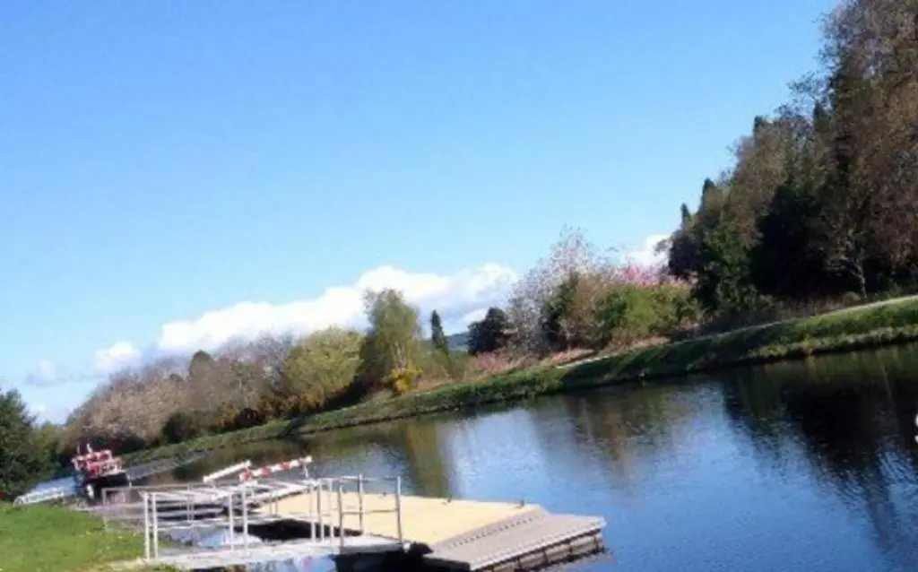 a boat is docked on the side of a river at 2 Bed Lodge - Sleeps 4 - Parking - Wifi in Inverness