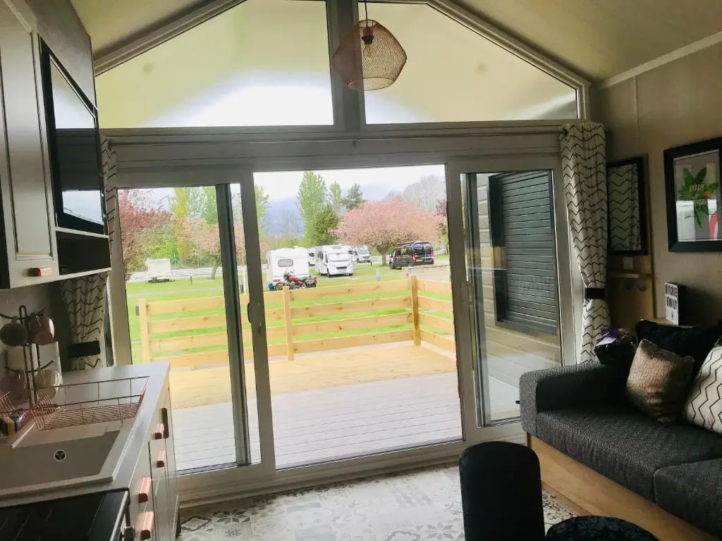 a living room with a sliding glass door with a view of a yard at 2 Bed Lodge - Sleeps 4 - Parking - Wifi in Inverness