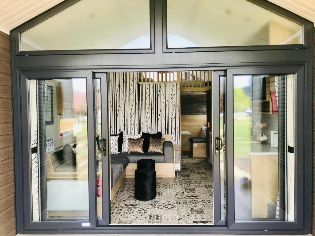 a living room with sliding glass doors and a couch at 2 Bed Lodge - Sleeps 4 - Parking - Wifi in Inverness