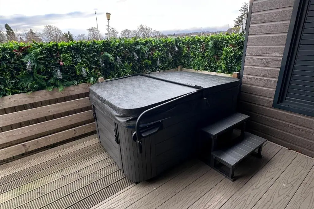 a black trash can sitting on a deck with a bench at Self-Catering Lodge with Hot Tub in Inverness