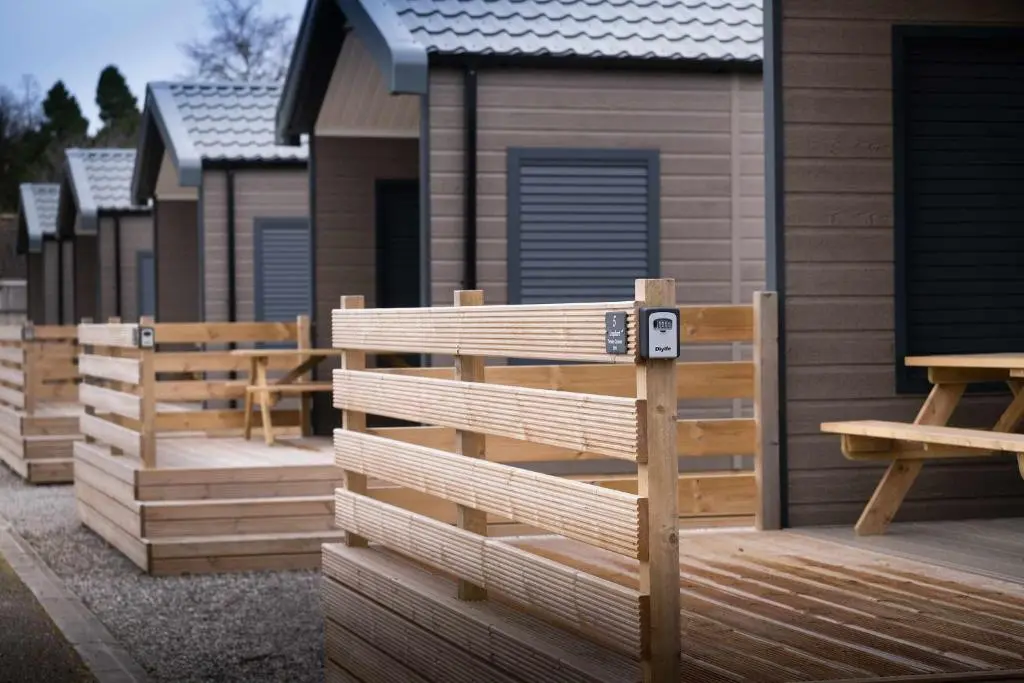 a row of wooden homes on a deck at Self-Catering Lodge with Hot Tub in Inverness