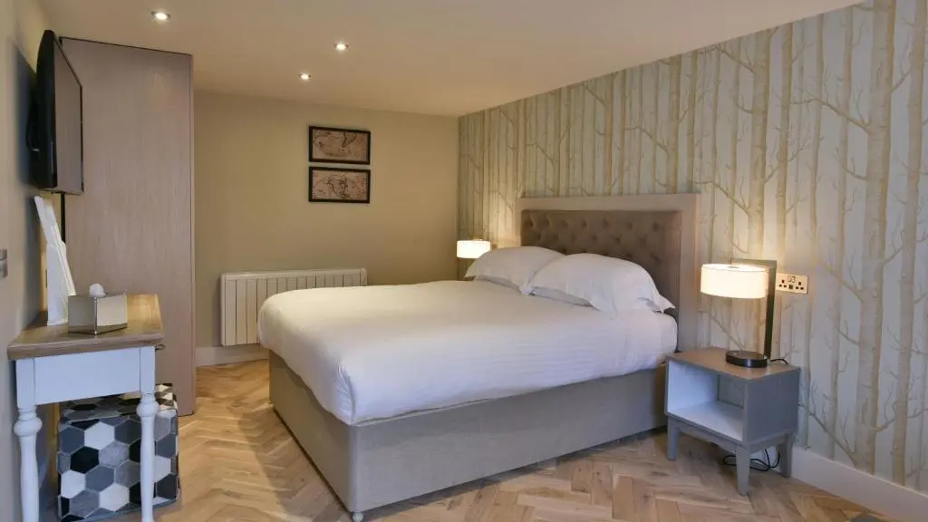 a bedroom with a bed and two lamps and a television at The Seafield Arms Hotel Cullen - Self Catering in Cullen