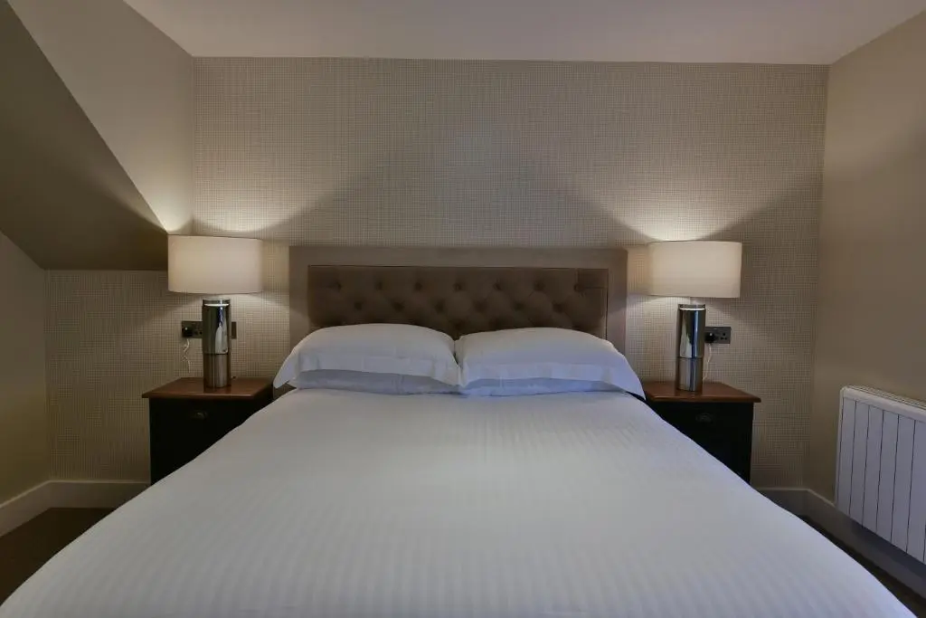 a bedroom with a large white bed with two lamps at The Seafield Arms Hotel Cullen - Self Catering in Cullen