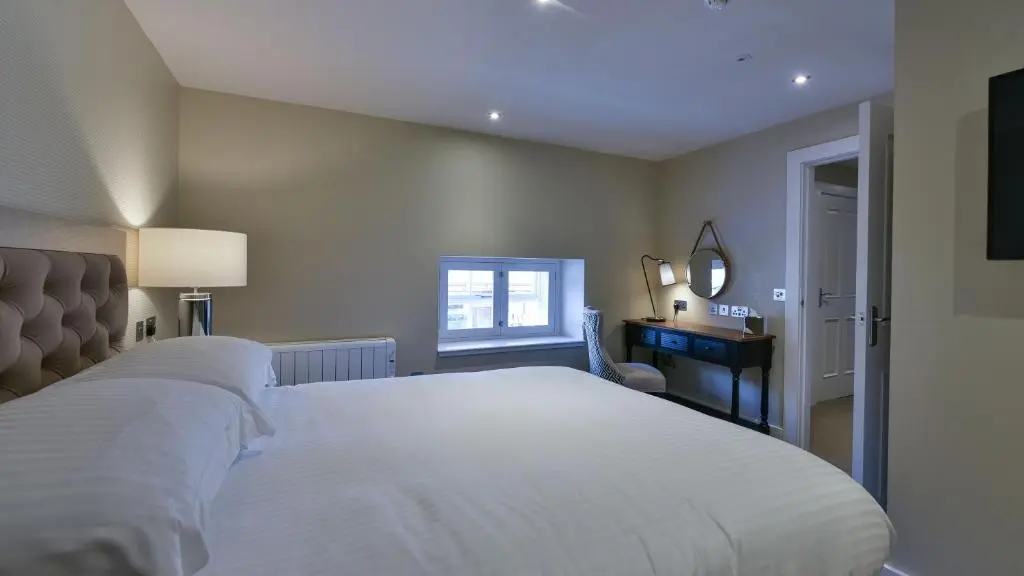a bedroom with a large white bed and a window at The Seafield Arms Hotel Cullen - Self Catering in Cullen