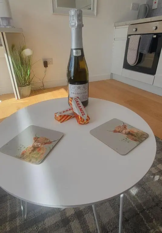 a bottle of wine sitting on top of a white table at The Nook in Inverness