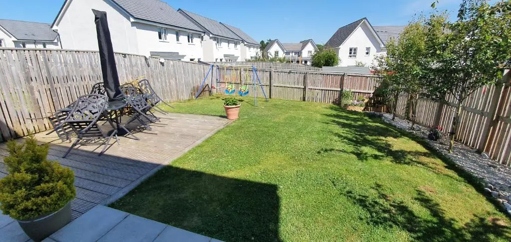 a backyard with a wooden fence and a playground at Kellys in Inverness