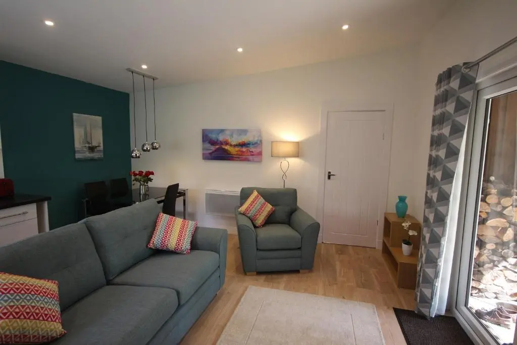 a living room with a couch and a chair at The Cabin at Easter Arr in Auldearn