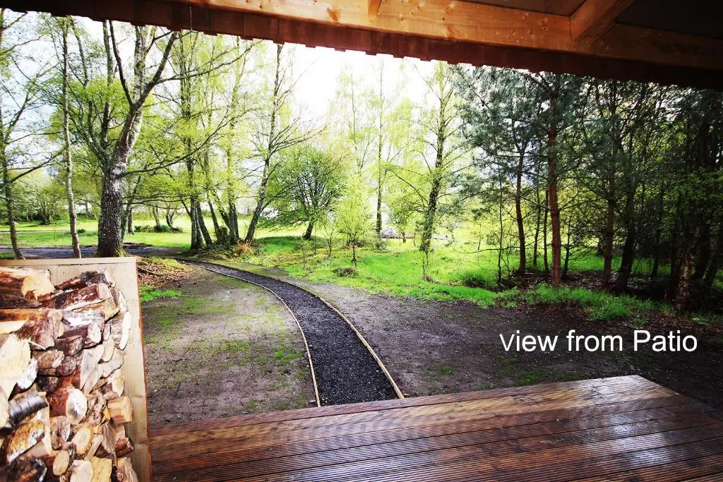 a view from a cabin window of a dirt road at The Cabin at Easter Arr in Auldearn