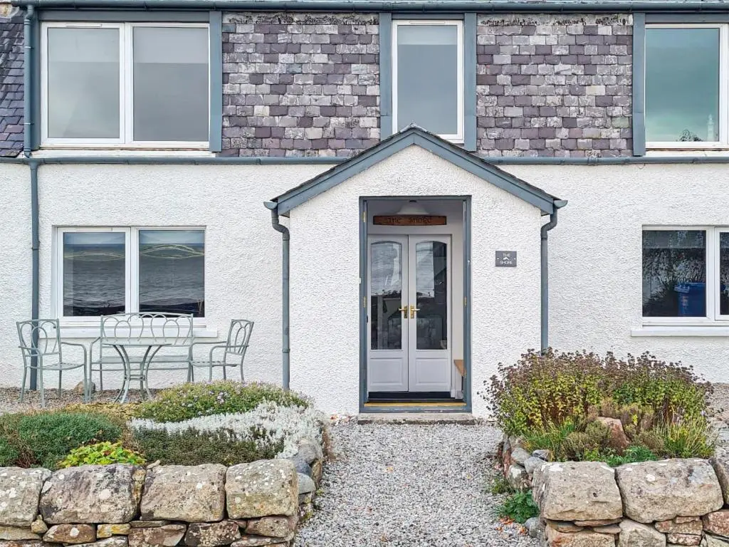 a white house with a table in front of it at The Shore in Fortrose