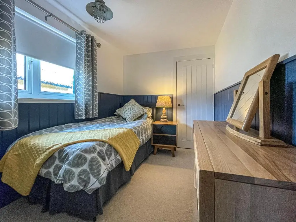 a bedroom with a bed and a window at Iseabail's House in Balintore