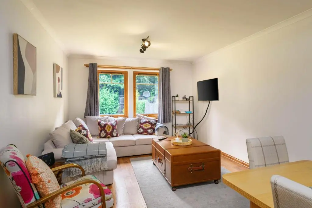 a living room with a couch and a table at The Nook Holiday Cottage in Aviemore