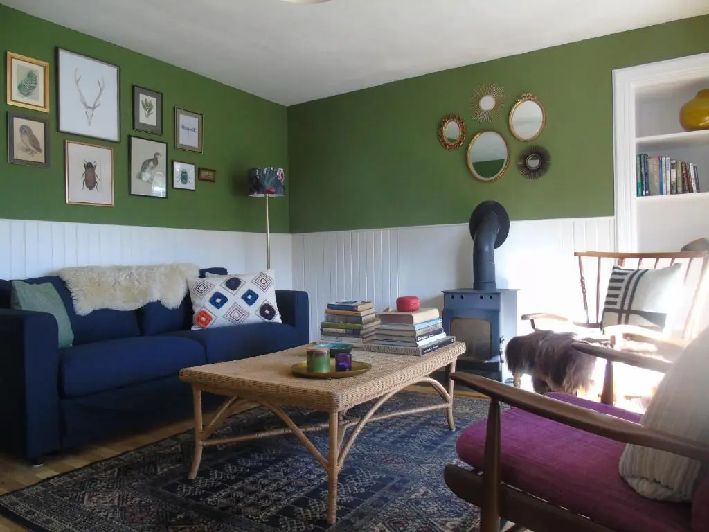 a living room with a blue couch and a table at Rowan Cottage, CrannachCottages in Garve