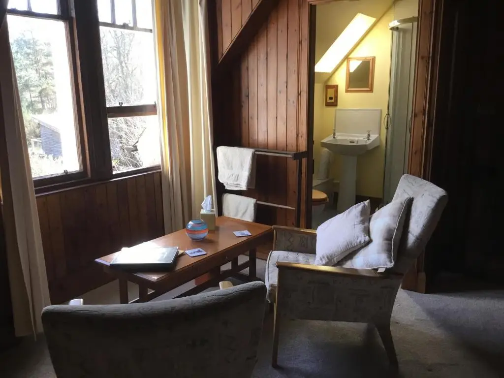 a living room with two chairs and a table and a sink at Westward Bed and Breakfast in Cannich