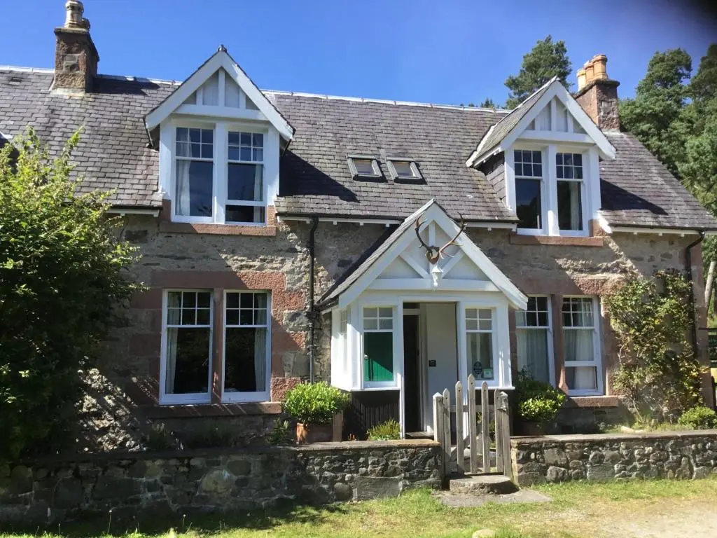 an old stone house with a white door at Westward Bed and Breakfast in Cannich