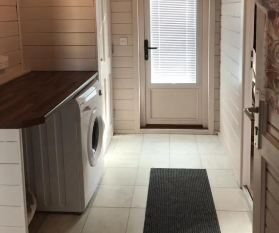 a laundry room with a washer and dryer next to a door at Lovely 1-Bed House in Fochabers Scotland in Fochabers