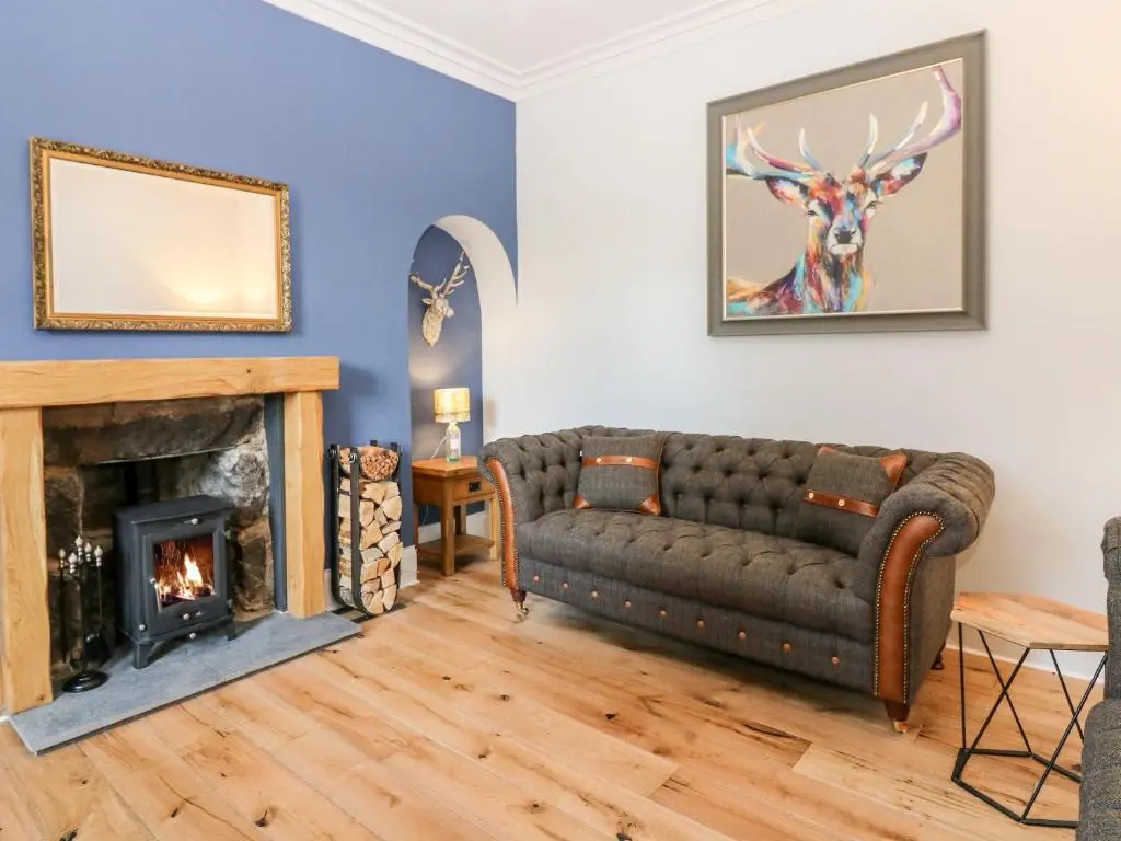 a living room with a couch and a fireplace at Gairnlea House in Ballater