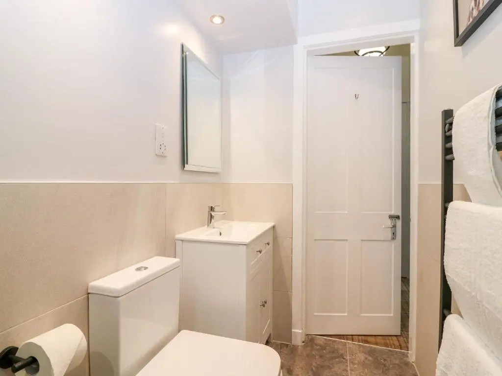 a white bathroom with a toilet and a sink at Gairnlea House in Ballater