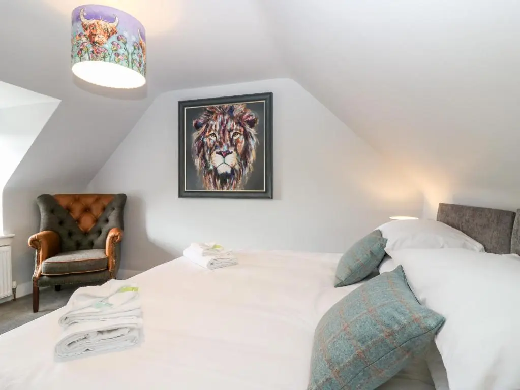 a bedroom with a bed with a painting of a tiger at Gairnlea House in Ballater