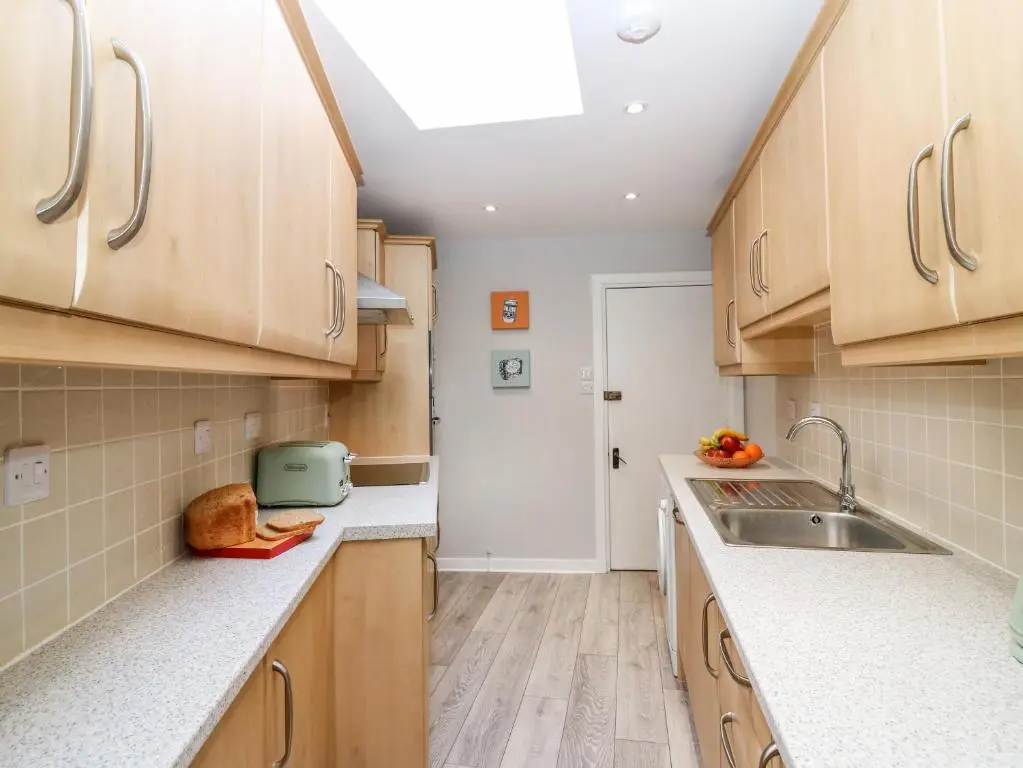 a kitchen with wooden cabinets and a sink at Gairnlea House in Ballater