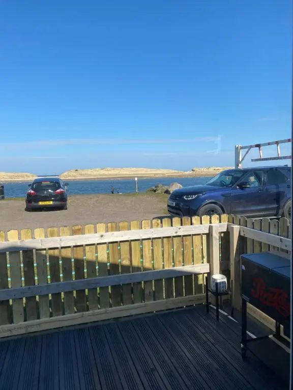 a car parked on a boardwalk next to the beach at Beachfront Lodge, Lossiemouth Bay in Lossiemouth