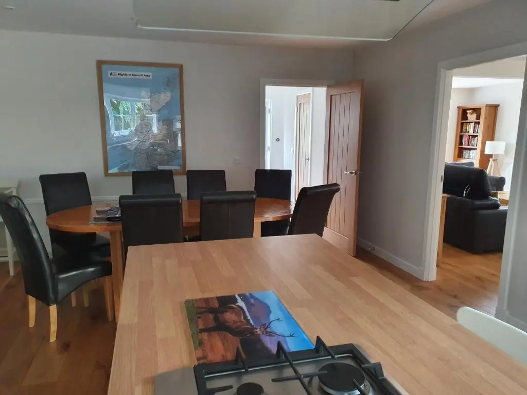 a living room with a dining room table and chairs at Loch Ness House Blairbeg in Drumnadrochit