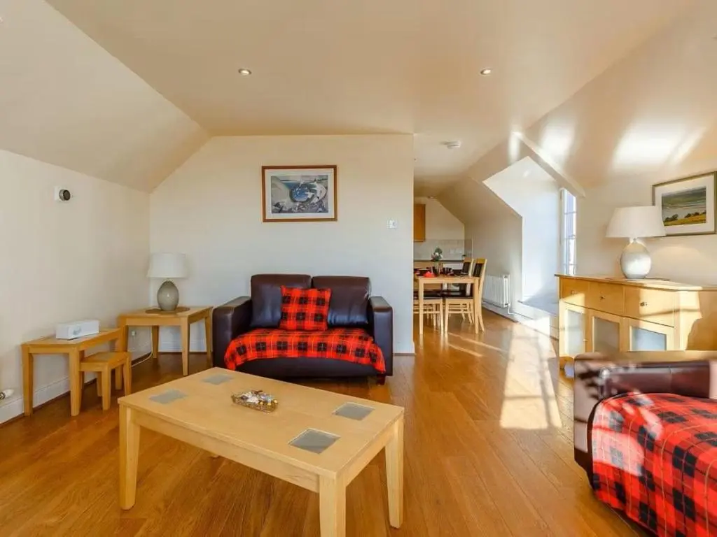 a living room with a couch and a table at Craiglea Lodge & Barn in Latheron