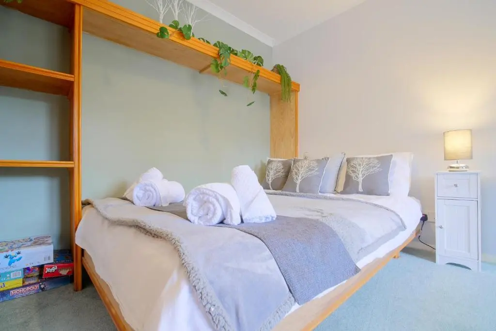 a bedroom with a large bed with towels on it at Silverglades Holiday Homes in Aviemore