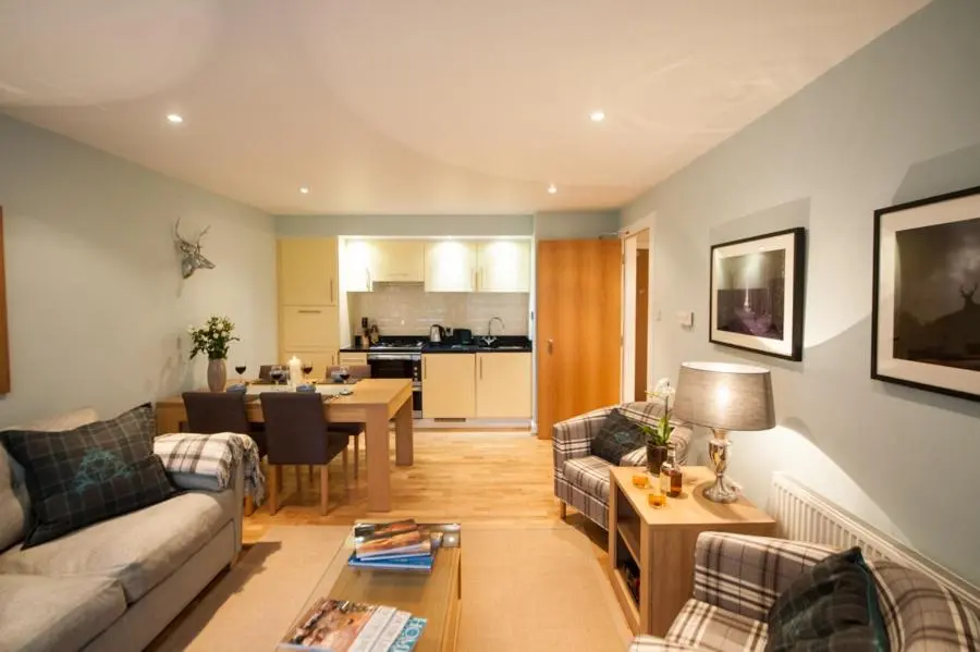 a living room with a couch and a table at Glenwood Apartment at The Highland Club in Fort Augustus