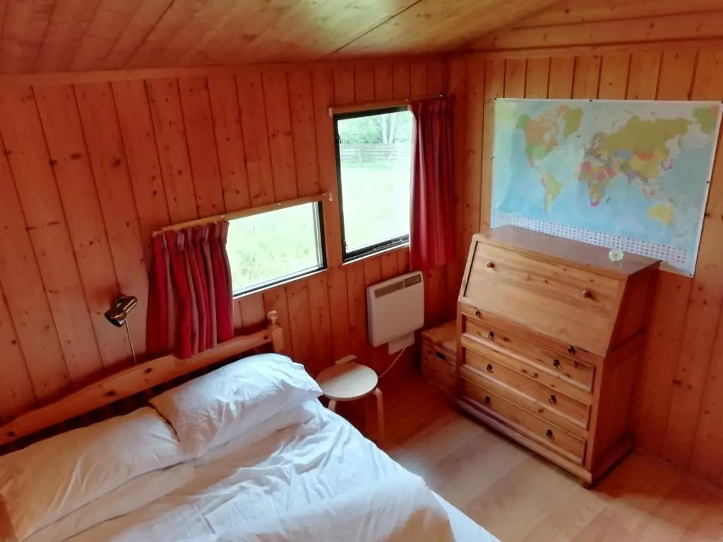 a bedroom with a bed and a map on the wall at Highland Lodge in Kilmorack