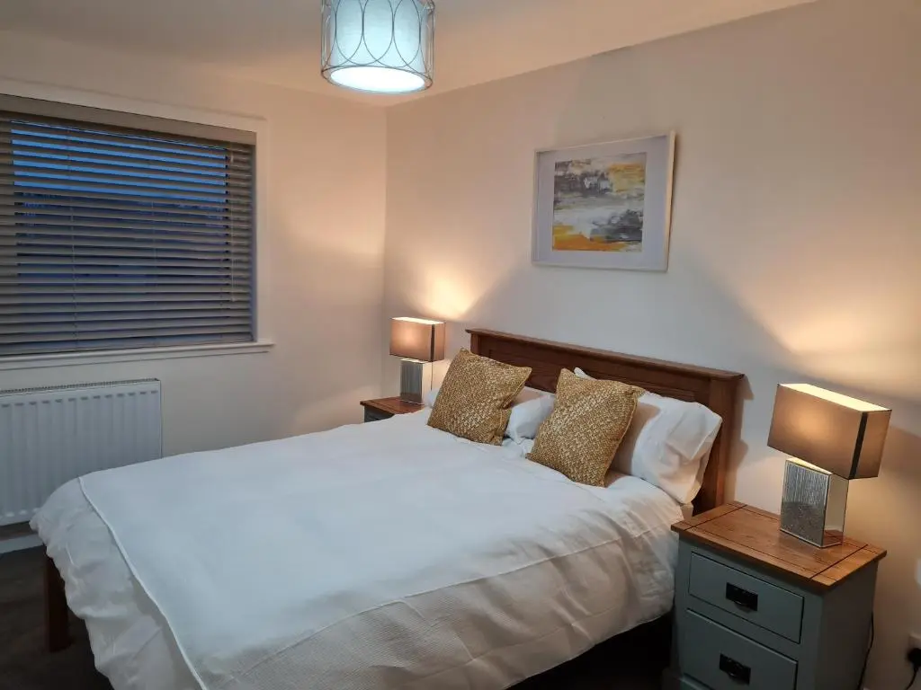 a bedroom with a white bed and two lamps at No 14, 3 BED all with SMART TV's, Fully Fitted Kitchen, Ample PARKING, Ideal for TRADES, BUSINESS wanting comfort and a quality service REDUCTIONS FOR LONGER STAYS Langley Cottages and Apartments, in Wick