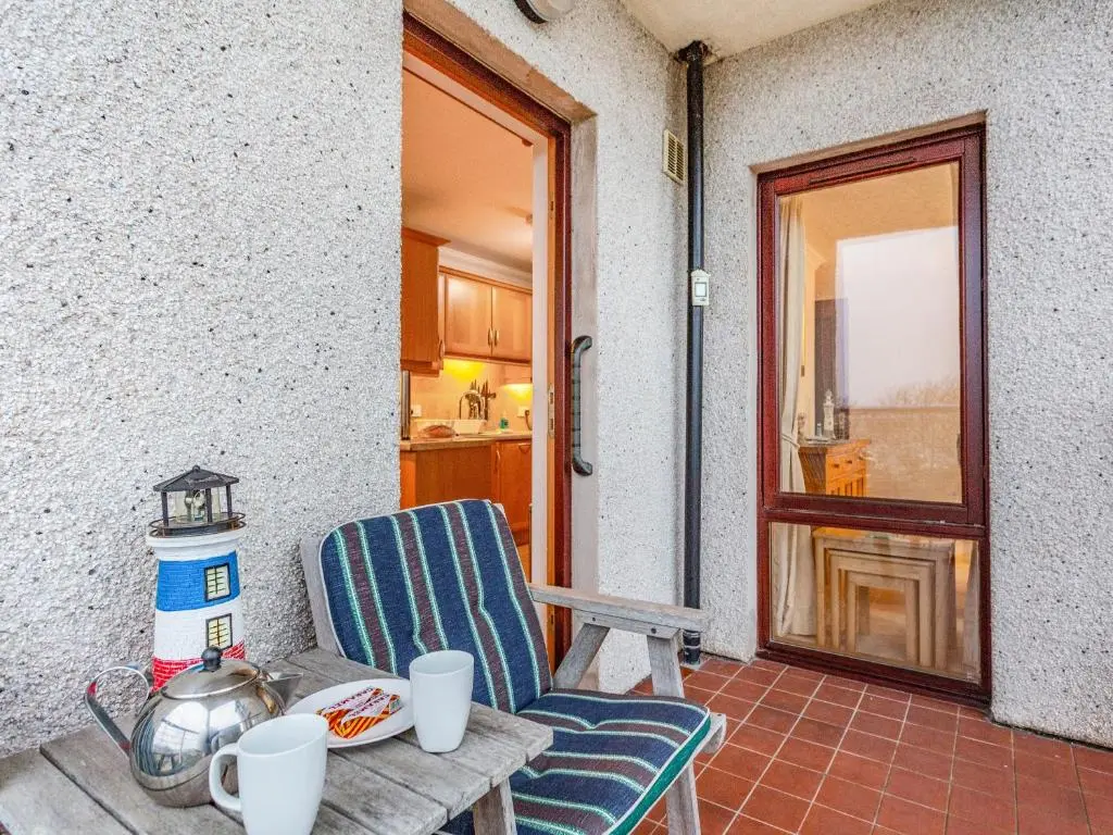 a patio with a chair and a table and a door at Moray Firth View in Nairn