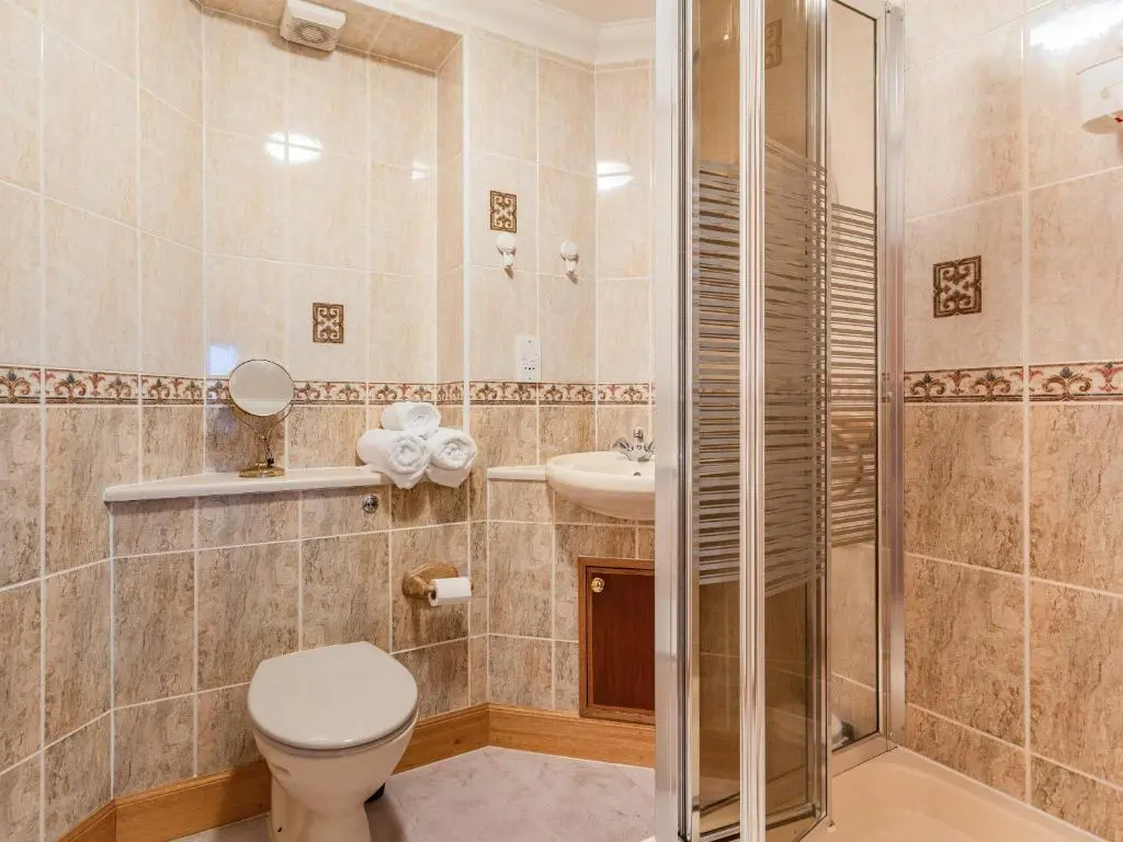 a bathroom with a toilet and a shower and a sink at Moray Firth View in Nairn