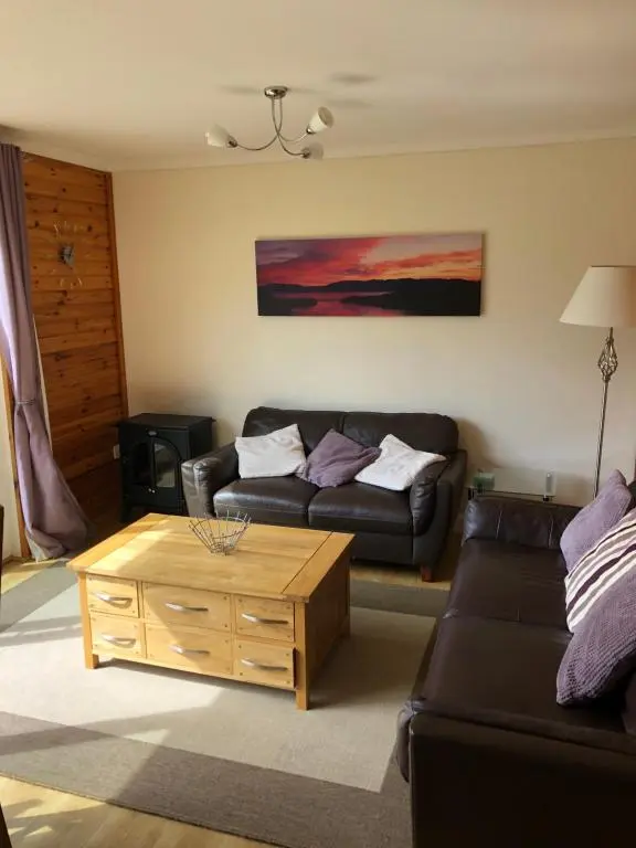 a living room with a couch and a coffee table at Ben Rinnes Lodge Glenlivet Highlands in Auchnastank