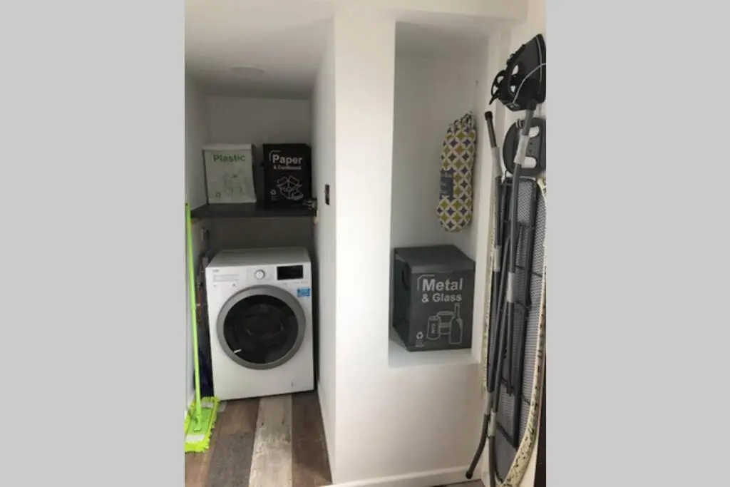 a laundry room with a washer and a washing machine at Seacot Cottage in the heart of the Highlands in South Kessock
