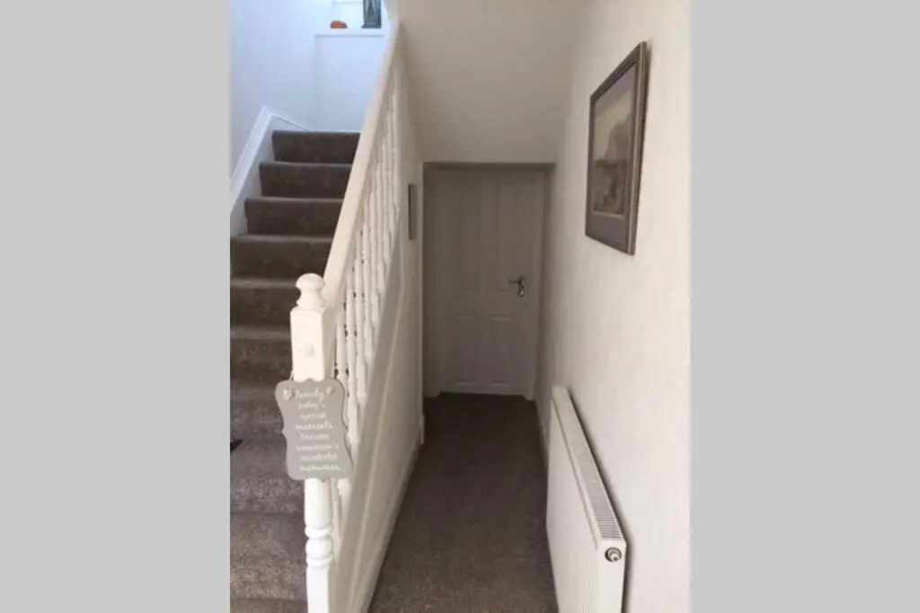a hallway with stairs and a door and a picture at Craigewan Cottage Seatown Cullen in Cullen