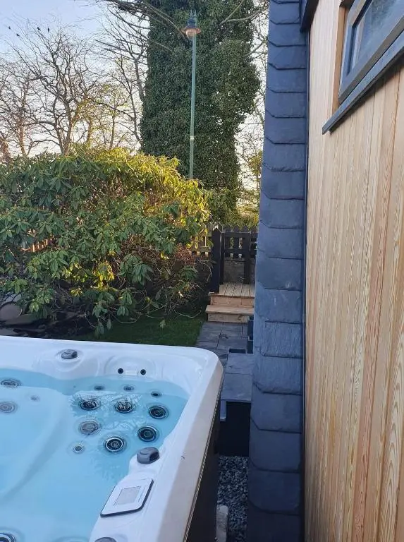 a bath tub in a yard next to a house at Little Woodbine in Tain