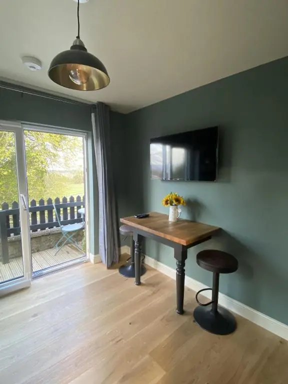 a dining room with a table and a window at Little Woodbine in Tain