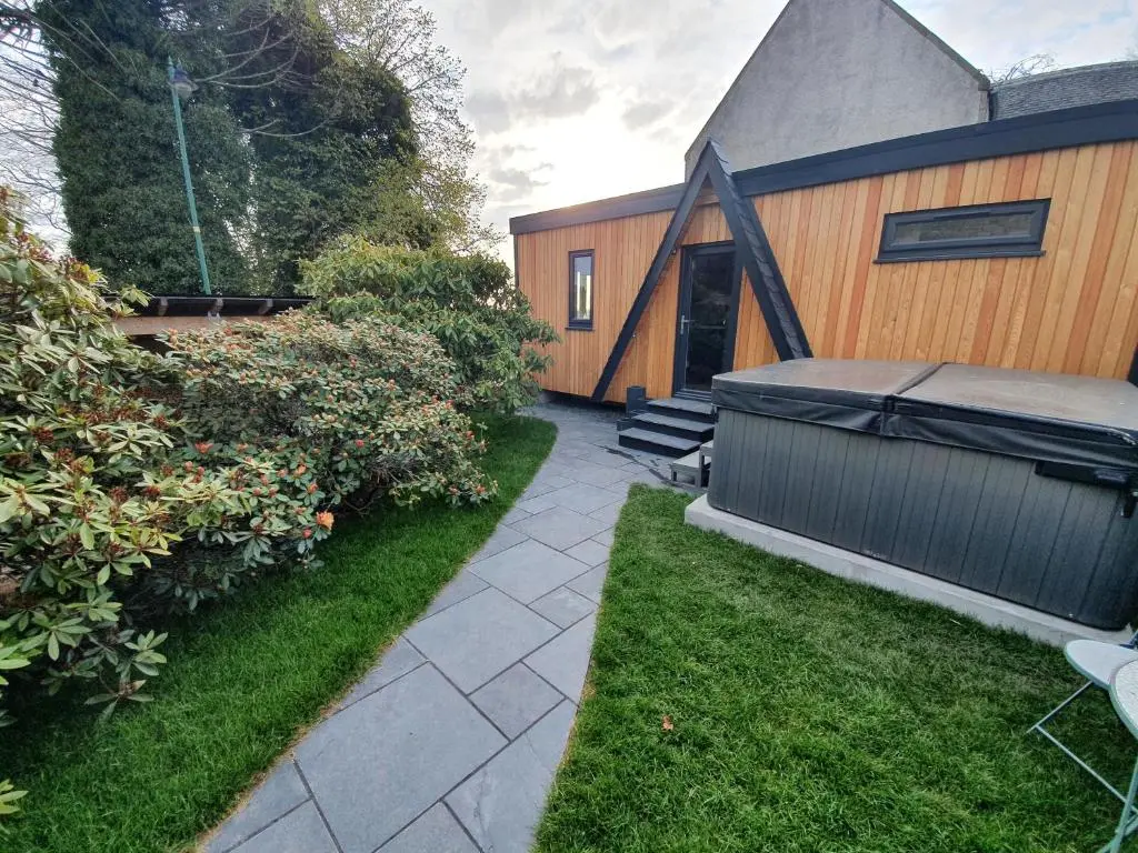 a backyard of a house with a hot tub at Little Woodbine in Tain