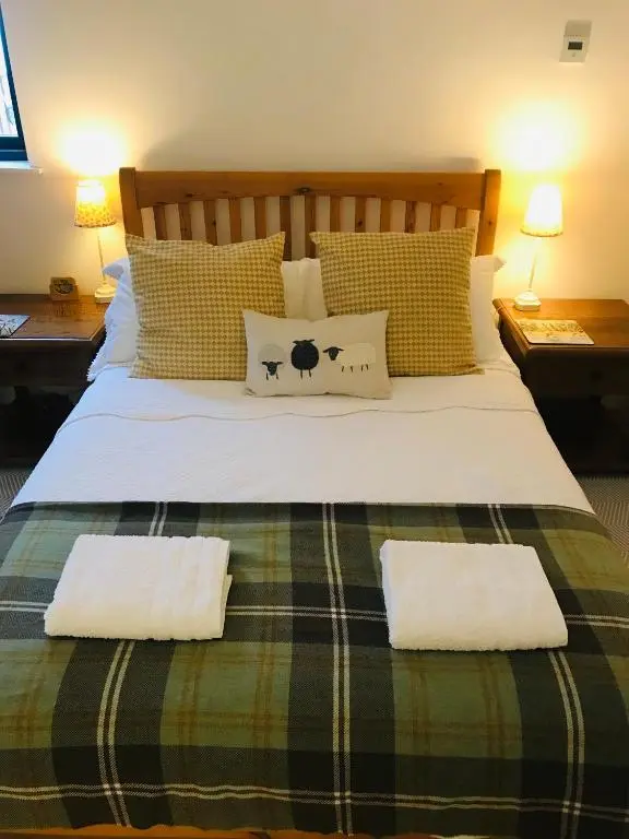a bedroom with a large bed with two pillows at Garden Retreat - City Central Quiet Garden Apartment with Free Parking in Inverness
