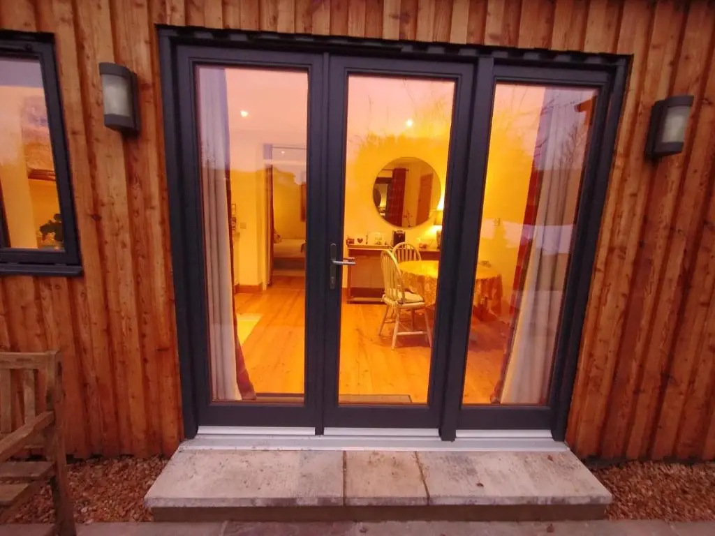 a sliding glass door in a room with a table at Garden Retreat - City Central Quiet Garden Apartment with Free Parking in Inverness