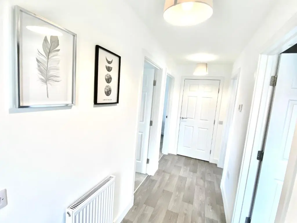 a hallway with white walls and wood floors at Serviced Accommodation Moray Cawdor Avenue, Elgin in Elgin
