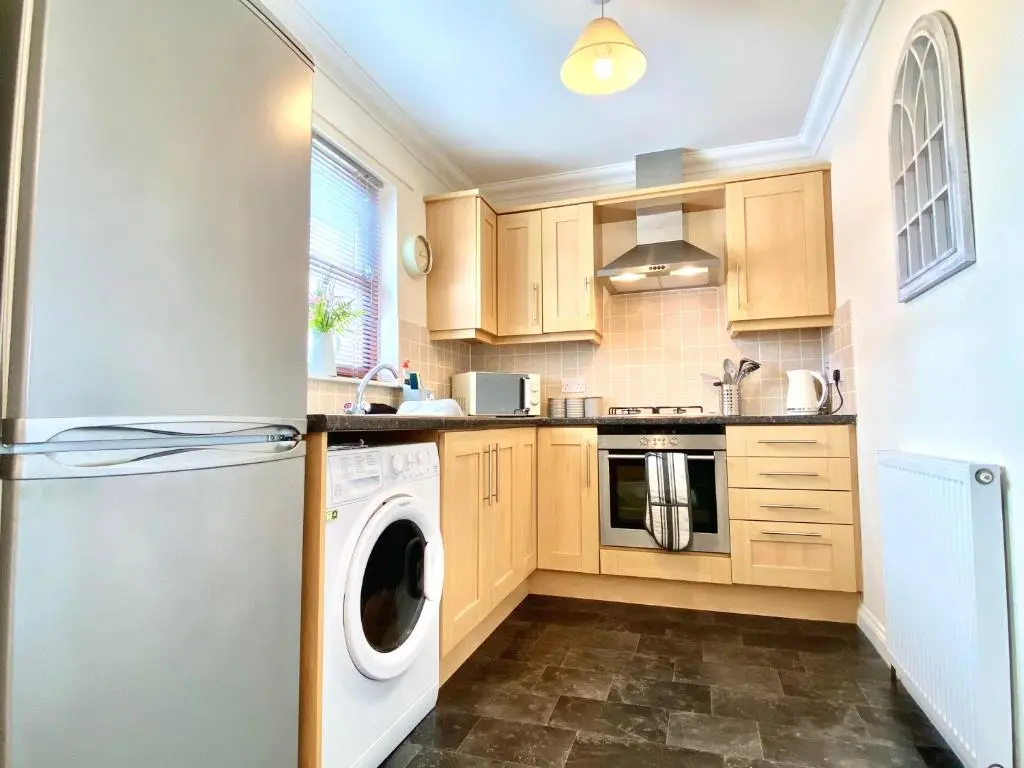 a kitchen with wooden cabinets and a washer and dryer at 100 Thornhill Drive, Elgin in Elgin