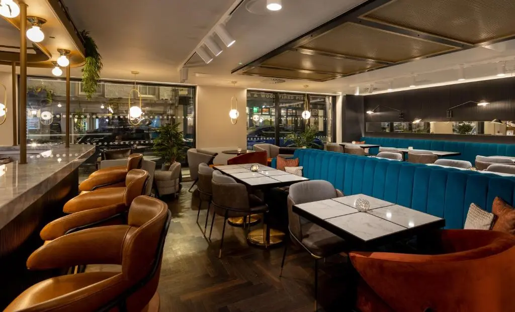 a restaurant with tables and chairs and a bar at River Ness Hotel, a member of Radisson Individuals in Inverness