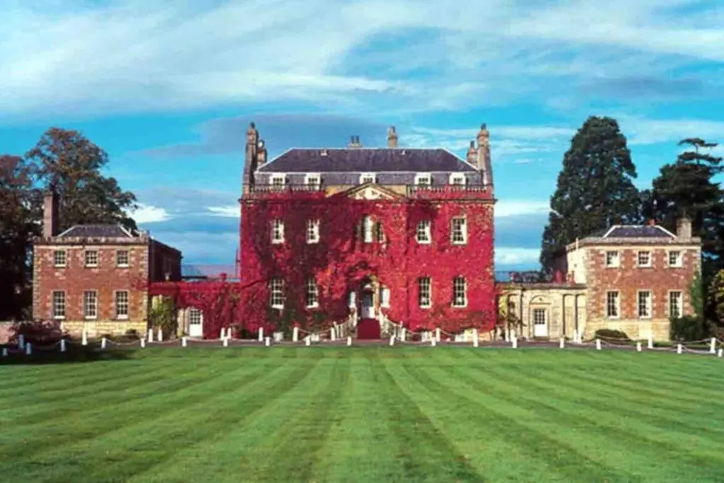 a large red brick building with a large grass field at Immaculate Cabin 5 mins to Inverness Dog friendly in Inverness